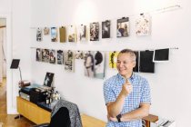 Editor sorridente contro parete con copertine per riviste — Foto stock