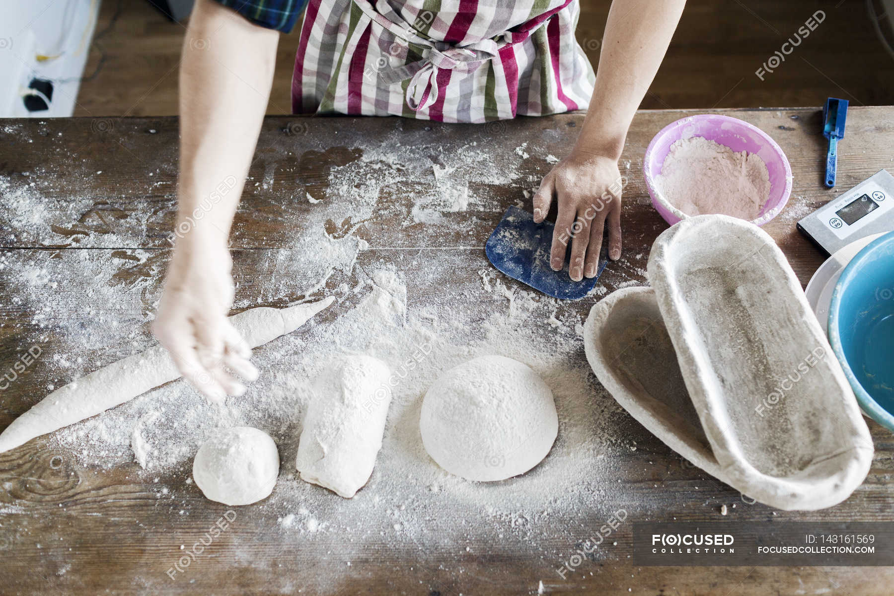 Hand dusting flour on dough in bakery — one, Color Image Stock Photo 143161569