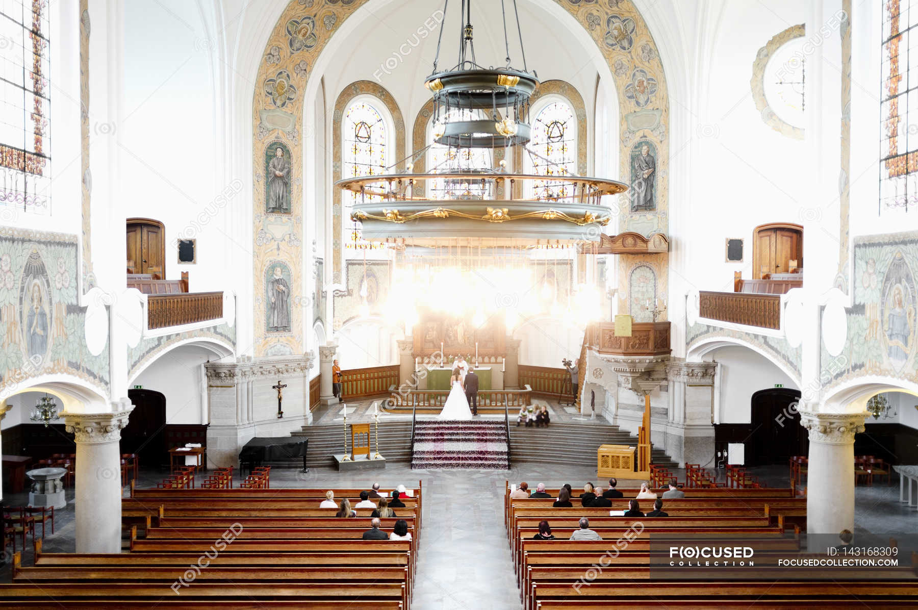 Wedding ceremony in church — woman, chandelier Stock Photo 143168309