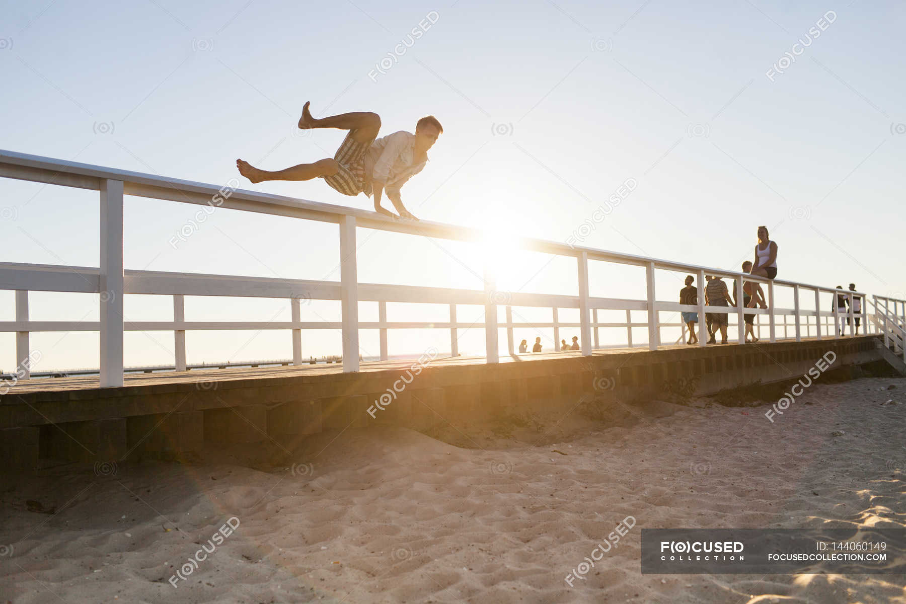 Man jumping over railing — outdoors, sunlight Stock Photo 144060149