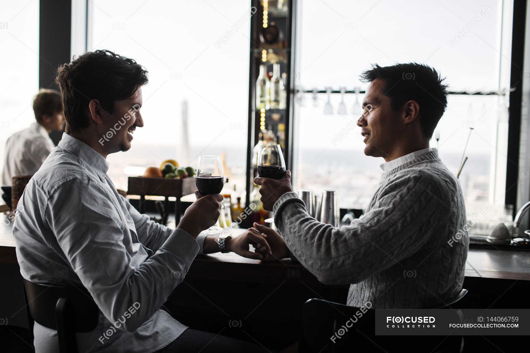 Young gay couple sitting at bar ??? Men, side view Stock Photo 144066759