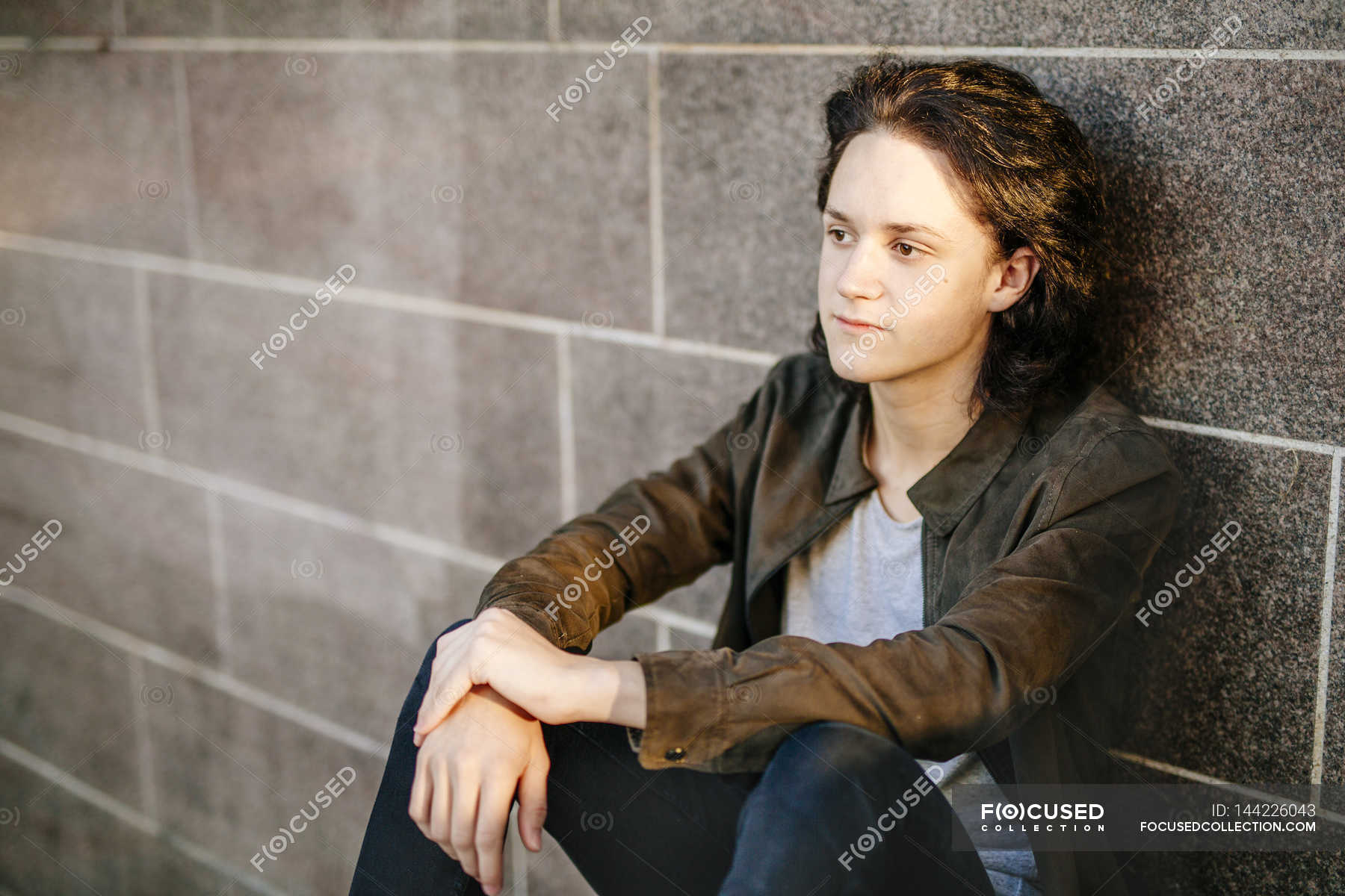 Boy leaning against stone wall, portrait - Stock Photo 