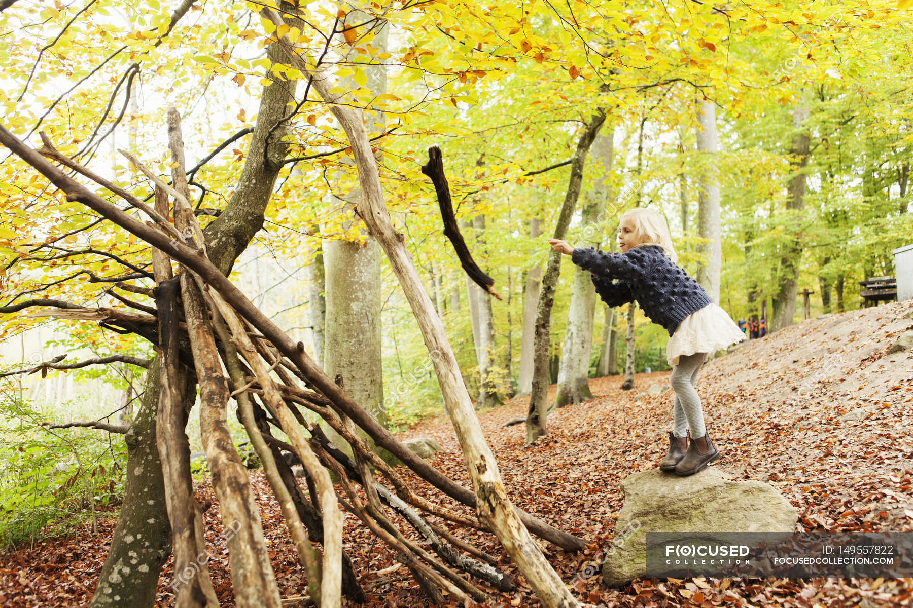 Girl throwing log in forest — change, fall - Stock Photo | #149557822