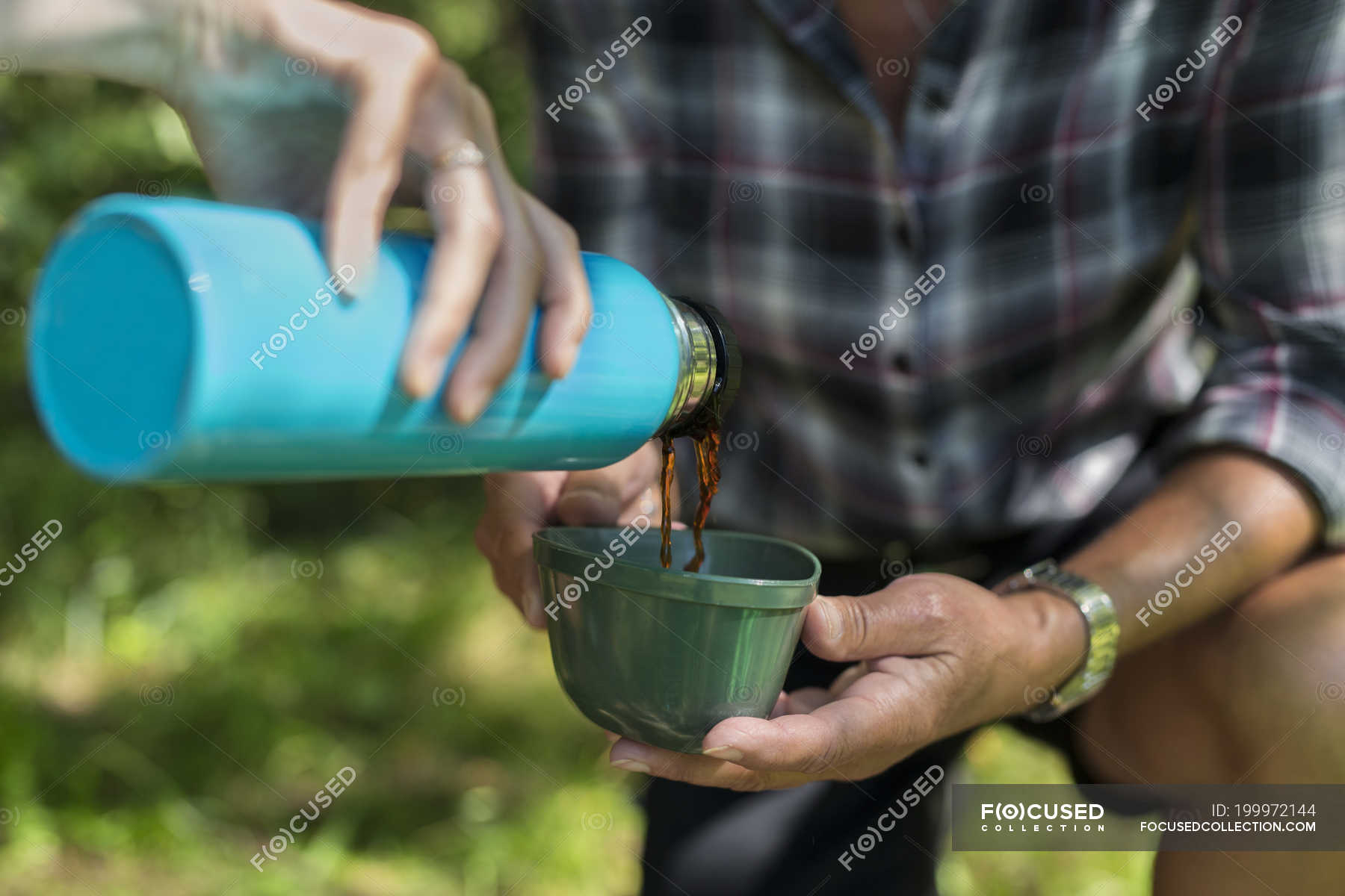 Young woman pouring drink from insulated drink container — together ...