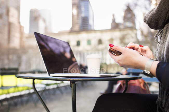Mulher com laptop e telefone inteligente — Fotografia de Stock
