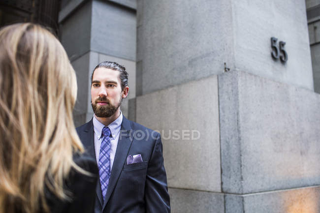 Businessman and businesswoman against building — Stock Photo