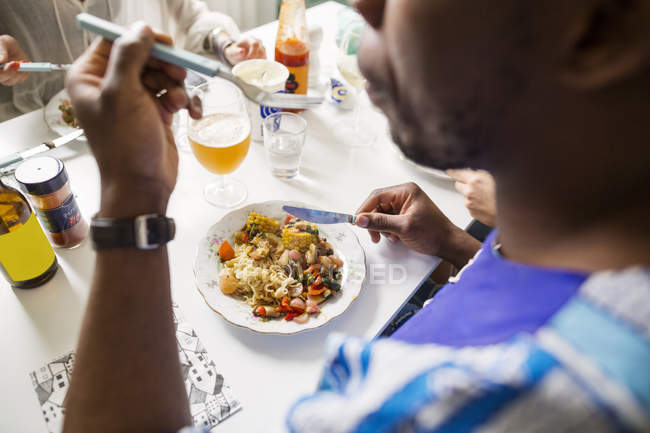 Amigos comendo comida à mesa — Fotografia de Stock