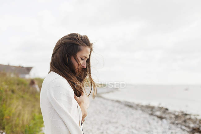 Frau blickt auf Strand herab — Stockfoto