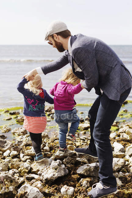 Hombre sosteniendo las manos de hija - foto de stock