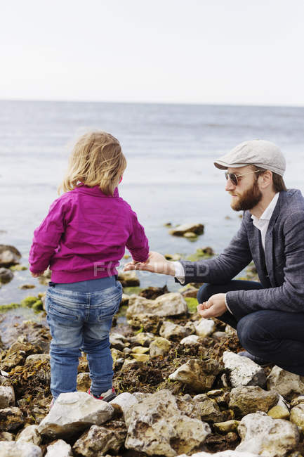 Father giving pebbles to daughter — Stock Photo