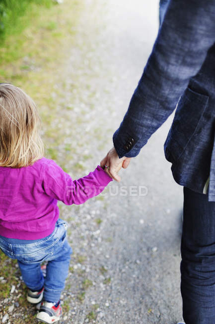 Отец и дочь держатся за руки — стоковое фото
