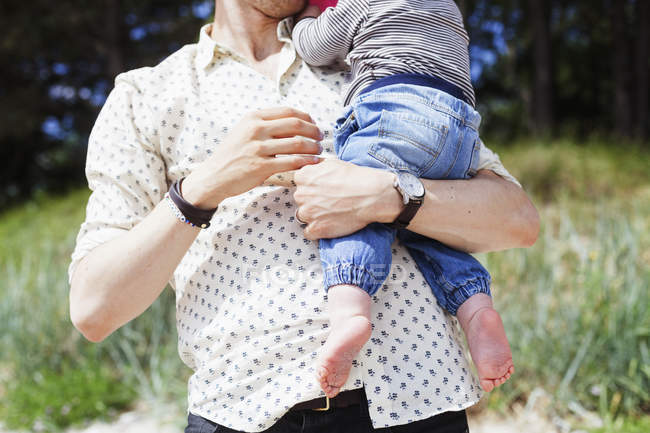 Hombre sosteniendo bebé niño - foto de stock