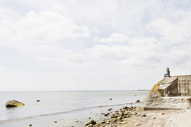Mulher sentada na rocha — Fotografia de Stock