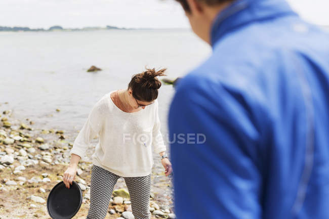 Donna e uomo in piedi sulla spiaggia — Foto stock