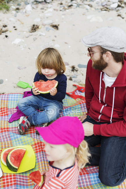 Famiglia godendo picnic in spiaggia — Foto stock
