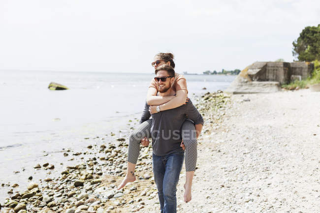 Man carrying friend on back — Stock Photo