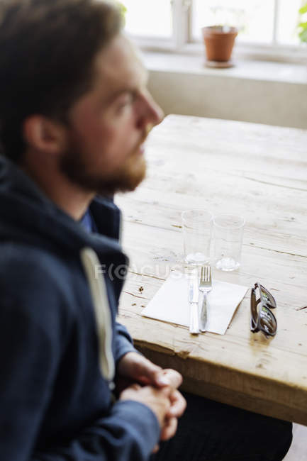 Jeune homme assis au restaurant — Photo de stock