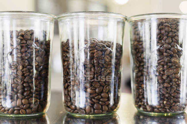 Roasted coffee beans in jars — Stock Photo