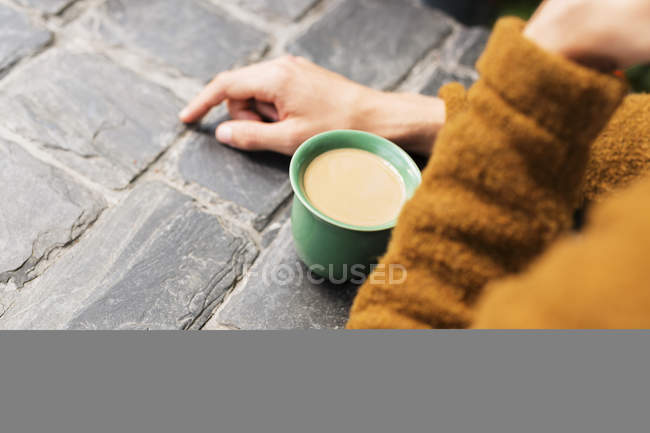 Людина з кавою на столі в теплиці — стокове фото