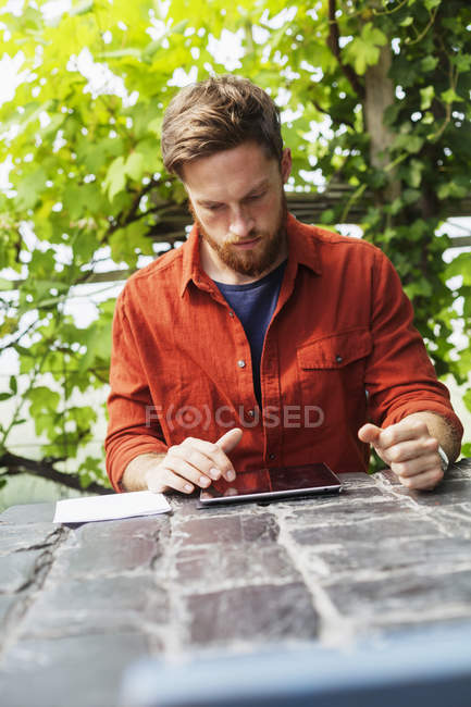 Man working on tablet at table — Stock Photo