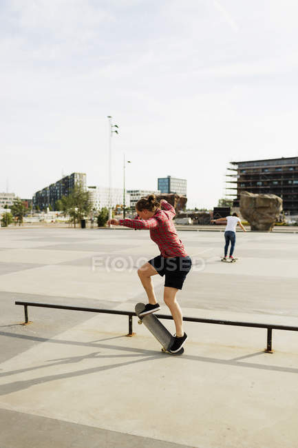 Mulher fazendo skate truque no parque — Fotografia de Stock