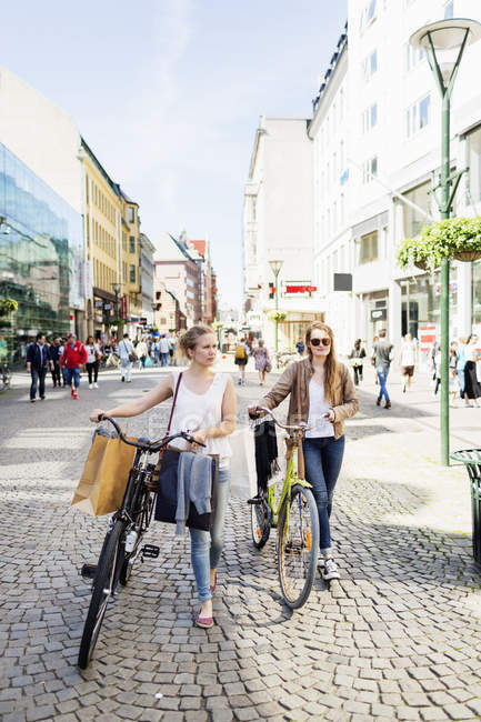 Жінки з велосипедами на вулиці — стокове фото