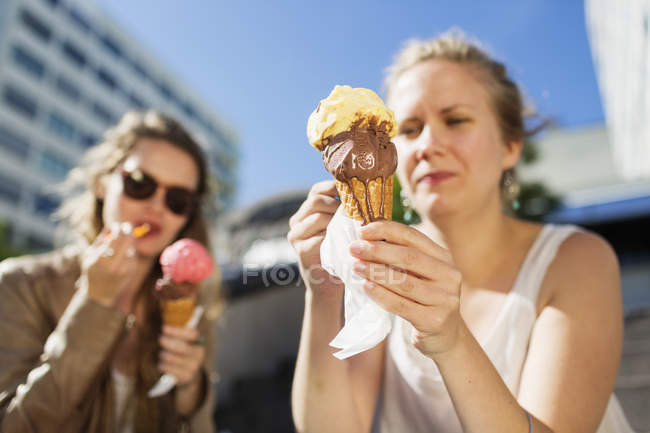 Mulheres segurando sorvetes derretendo — Fotografia de Stock