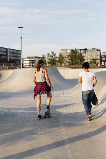 Скейтбординг девочек-подростков в скейтпарке — стоковое фото