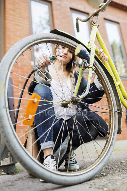 Mulher inflando pneu de bicicleta — Fotografia de Stock