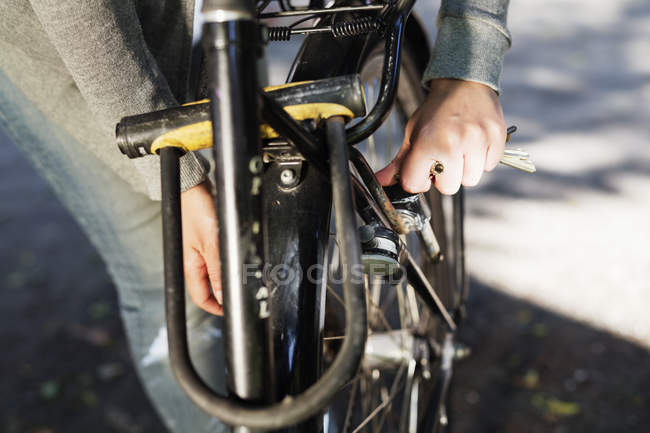 Main de femme verrouillage vélo — Photo de stock