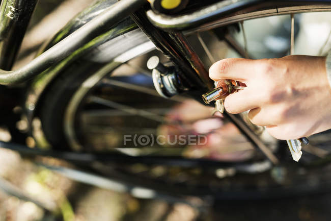 Donna che tiene chiave di blocco della bicicletta — Foto stock