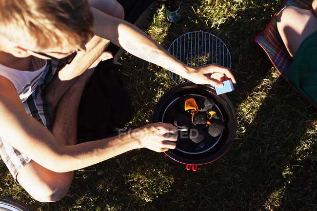 Homme préparant barbecue au pique-nique — Photo de stock