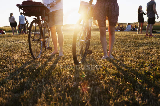 Amis marchant avec des vélos sur le terrain — Photo de stock