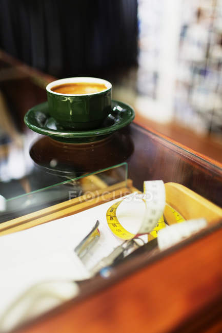 Taza de café en la mesa en tienda de ropa - foto de stock