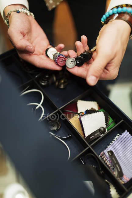 Fashion designer choosing buttons — Stock Photo
