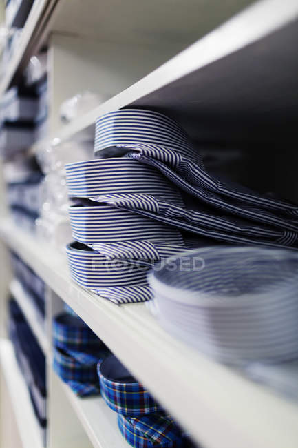Camisas empilhadas em prateleiras — Fotografia de Stock