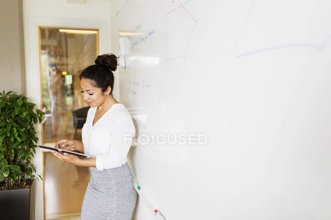 Businesswoman standing and using digital tablet — Stock Photo