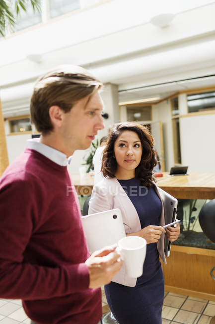 Geschäftsfrau steht neben männlichem Kollegen — Stockfoto