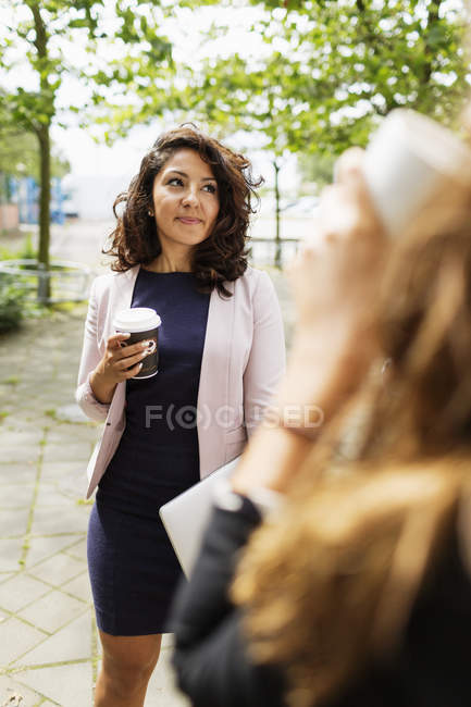 Junge Geschäftsfrau hält Kaffee — Stockfoto