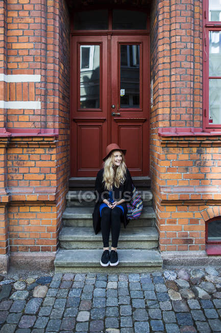 Frau schaut weg, während sie auf Stufen sitzt — Stockfoto