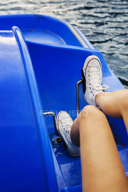 Jambes féminines pédalage bateau — Photo de stock