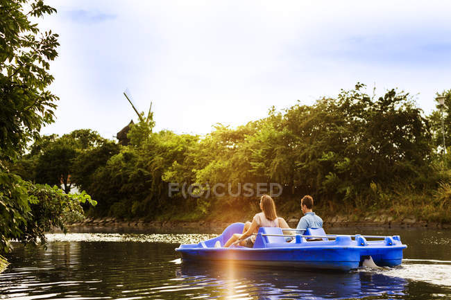 Друзі педалі на човні на річці — стокове фото