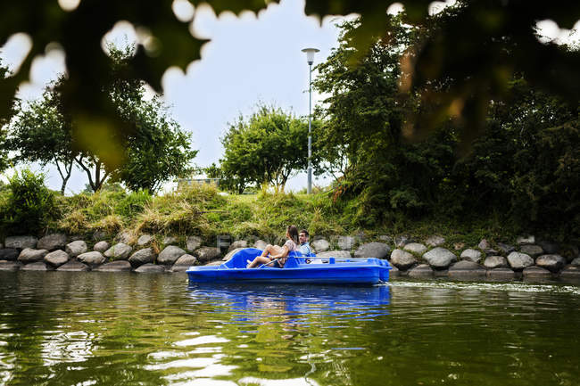 Amigos pedal barco en el río - foto de stock
