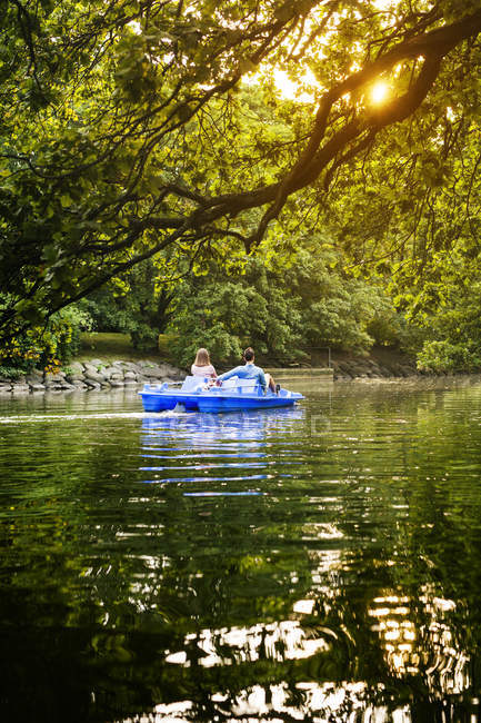Friends pedal boating on channel — Stock Photo