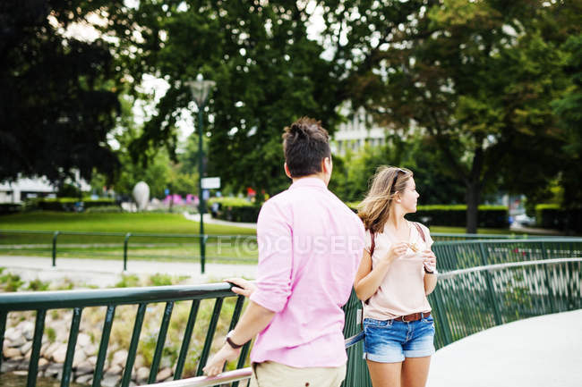 Friends standing on footbridge in park — Stock Photo