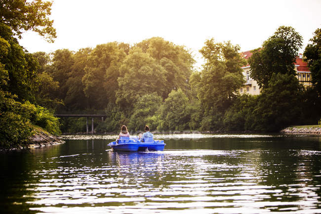 Friends pedal boating on channel — Stock Photo
