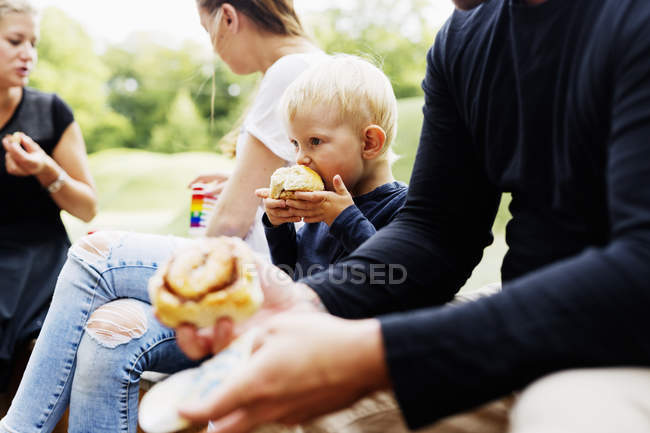 Familia comiendo en el parque - foto de stock