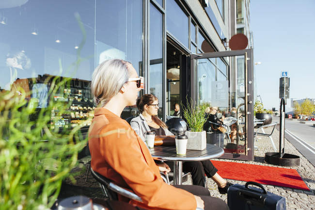 Femmes d'affaires regardant loin tout en étant assis au café — Photo de stock
