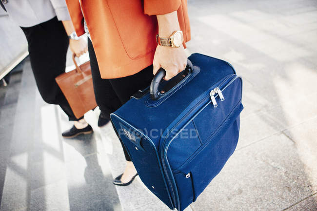 Бізнес-леді з багажем, що рухається вниз кроки — стокове фото