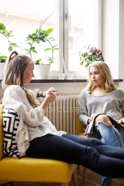 Amigos do sexo feminino discutir na sala de estar — Fotografia de Stock